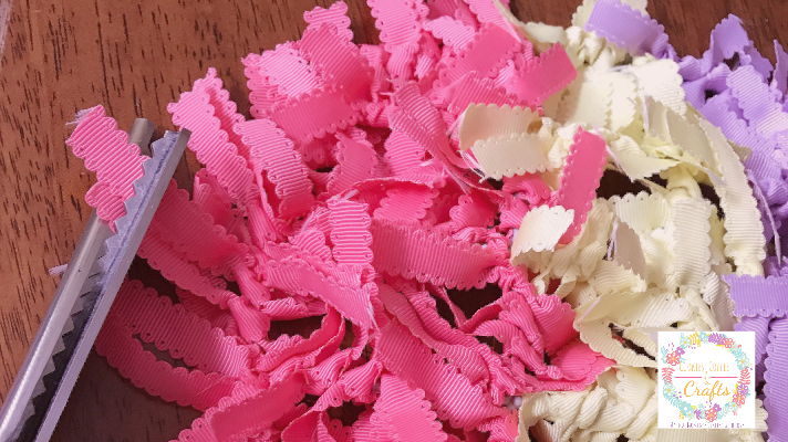 Using pinking shears to make nice edges on the ribbon for the egg shaped wreath 