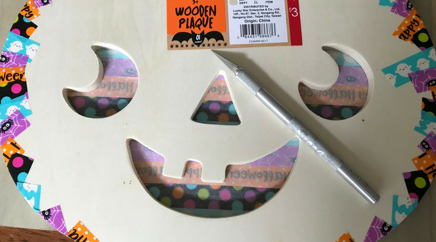 Use the exacto knife to cut the jack o lanterns face out of the Washi tape