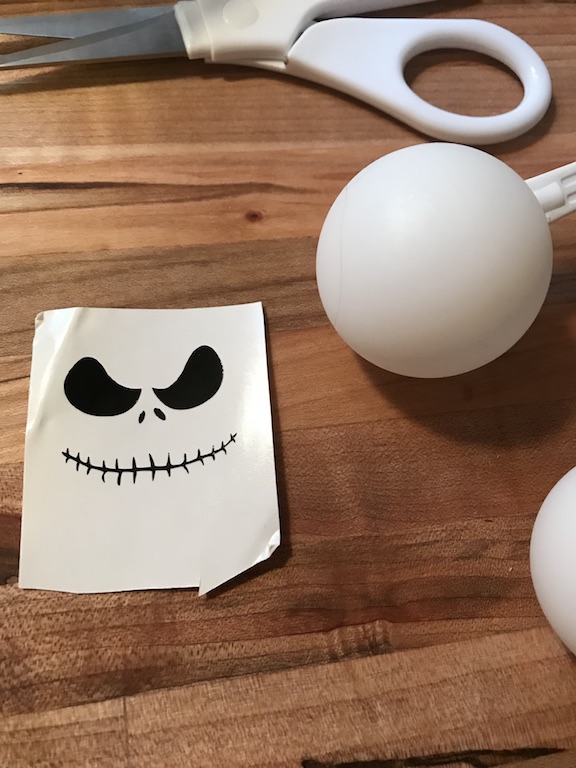  Ping Pong Ball Lights are easy and fun to make. Learn how to make these spooky halloween Jack Skellington lights. The kids and adults will love the design and creativity. #JackSkellington #NightmareBeforeChristmas #PingPongBalls #DIY #Kids #Fun #HowtoMake #HalloweenParty #Halloween #HalloweenDecor #HalloweenIdeas #Vinyl #CricutMade 