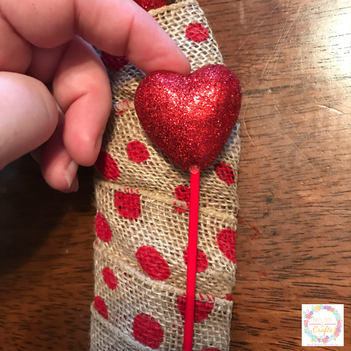 Adding glitter heart picks to heart wreath 
