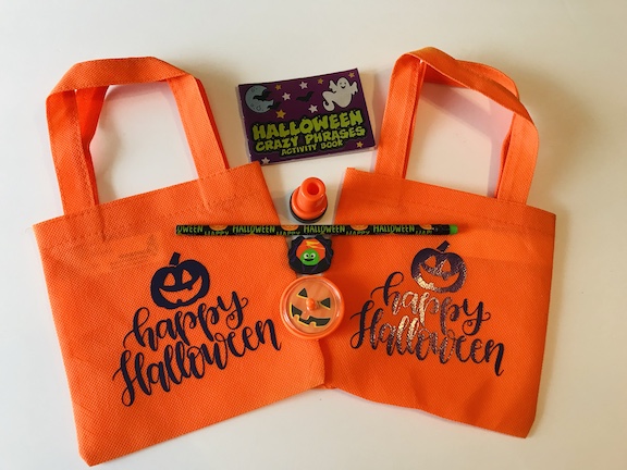 Surprise your kids with cute Happy Halloween trick or treat bags made with the Cricut. This easy DIY is great to hand out in the classroom for Halloween. Choose a cute SVG and create these homemade bags. #Halloween #TrickorTreatBags #CricutMade