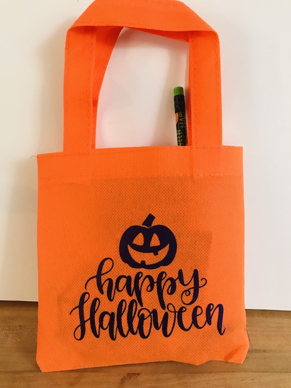  Surprise your kids with cute Happy Halloween trick or treat bags made with the Cricut. This easy DIY is great to hand out in the classroom for Halloween. Choose a cute SVG and create these homemade bags. #Halloween #TrickorTreatBags #CricutMade 