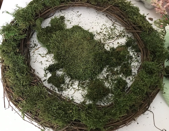 Hot glue the moss to the entire grapevine wreath 