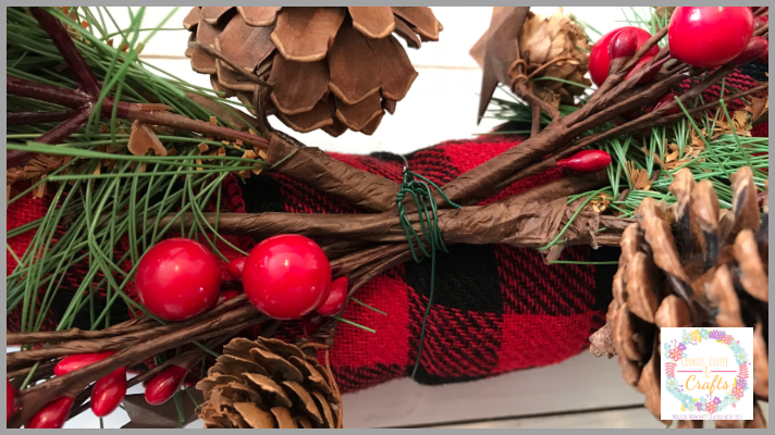 Attach the evergreens, pinecones, and berries to the Christmas Ribbon Wreath