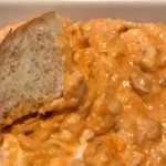 Dipping bread into buffalo chicken dip