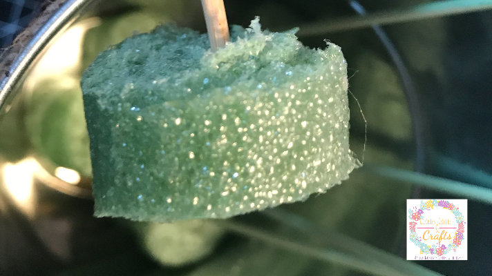 Cutting the floral foam wreath into circles to use top ut the wooden skewers inside the metal bucket for the 3D paper tulip bouquet