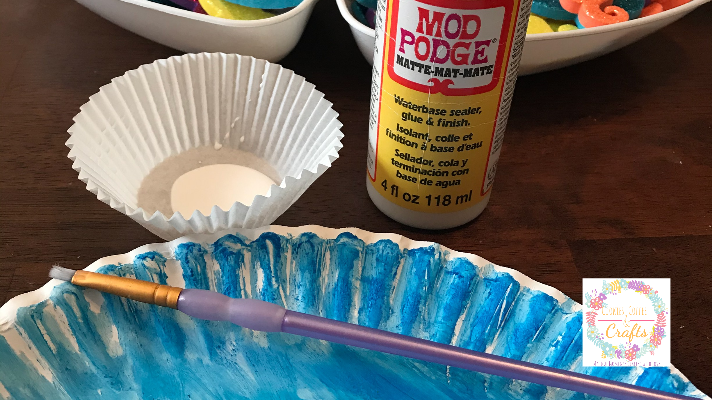 how to apply the Mod Podge with a paintbrush to add on the shredded paper to the ocean art