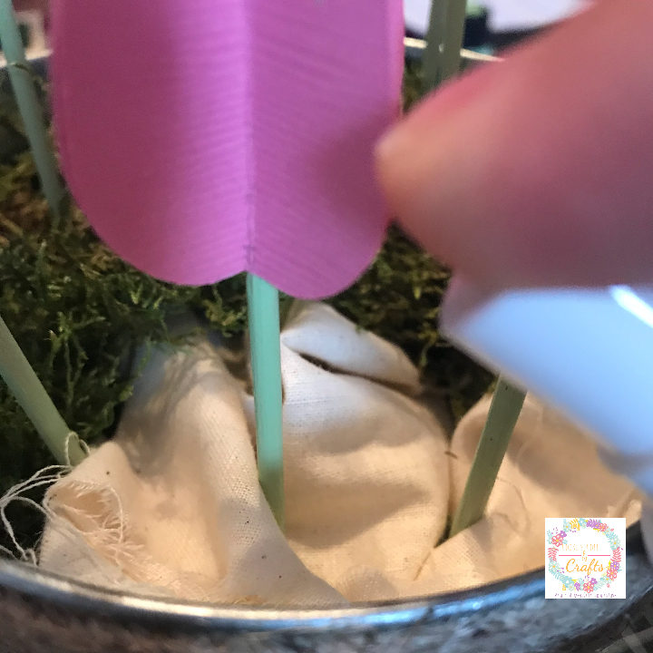 Using Mod Podge ultra spray to add the moss to the top of the bucket and to cover the fabric