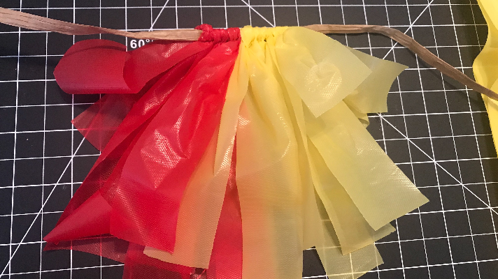 Creating a car parade decoration with a multi colored plastic tablecloths 