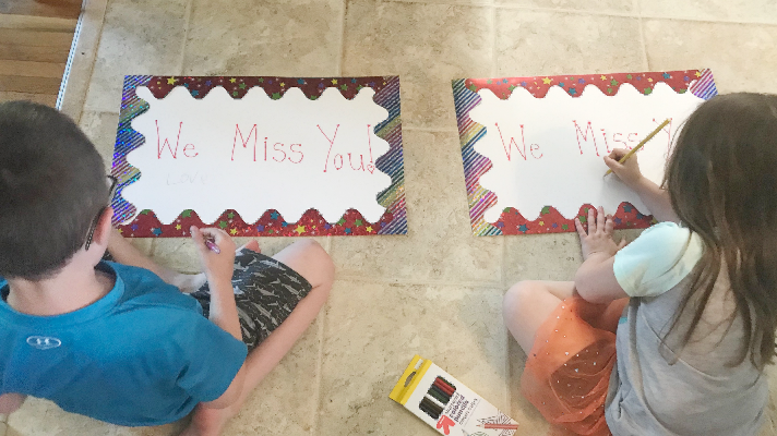 Kids making posters for teacher car parade decorations