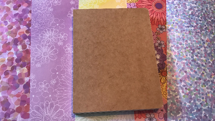 Adhesive backed paper to decorate a notebook cover to have a homemade notebook