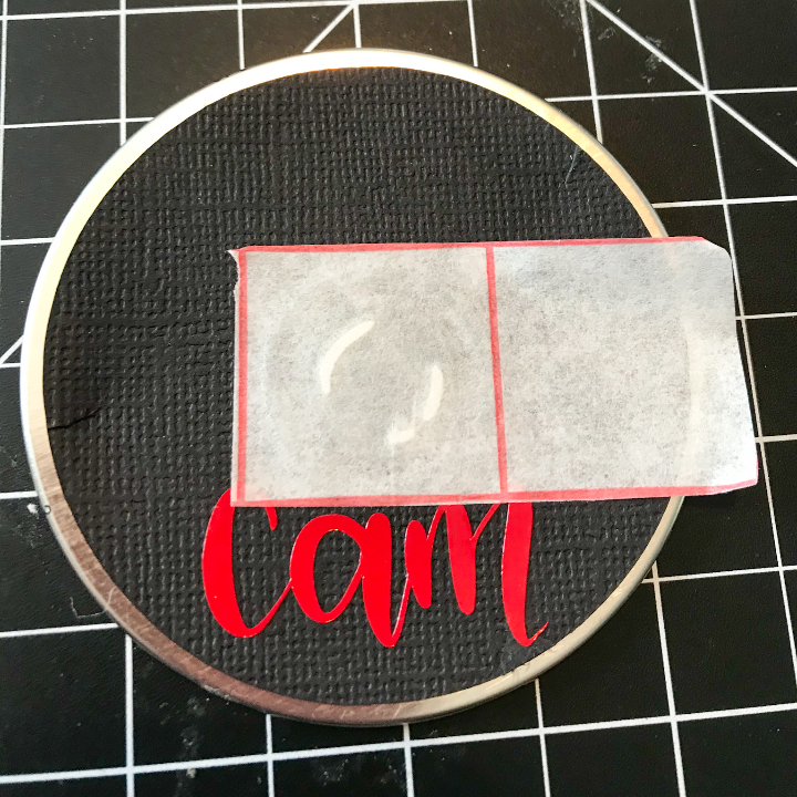 Use transfer tape to add the elf spy camera to the DIY Christmas ornament