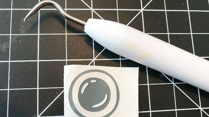 Weed the vinyl words and spy camera to add to the Cricut Christmas Ornament