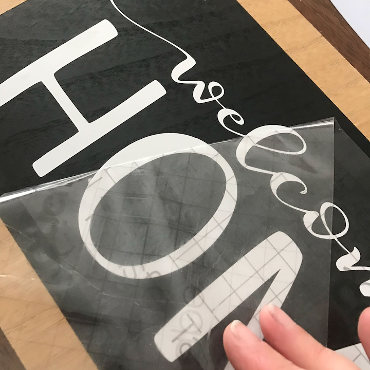 Gently start peeling the transfer tape at an angle and removing it from the sign