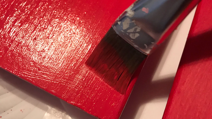 Painting the 2x4 red for the faux valentine mini book stack