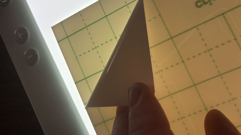 Peeling off the smart vinyl to remove the extra vinyl to weed the sign