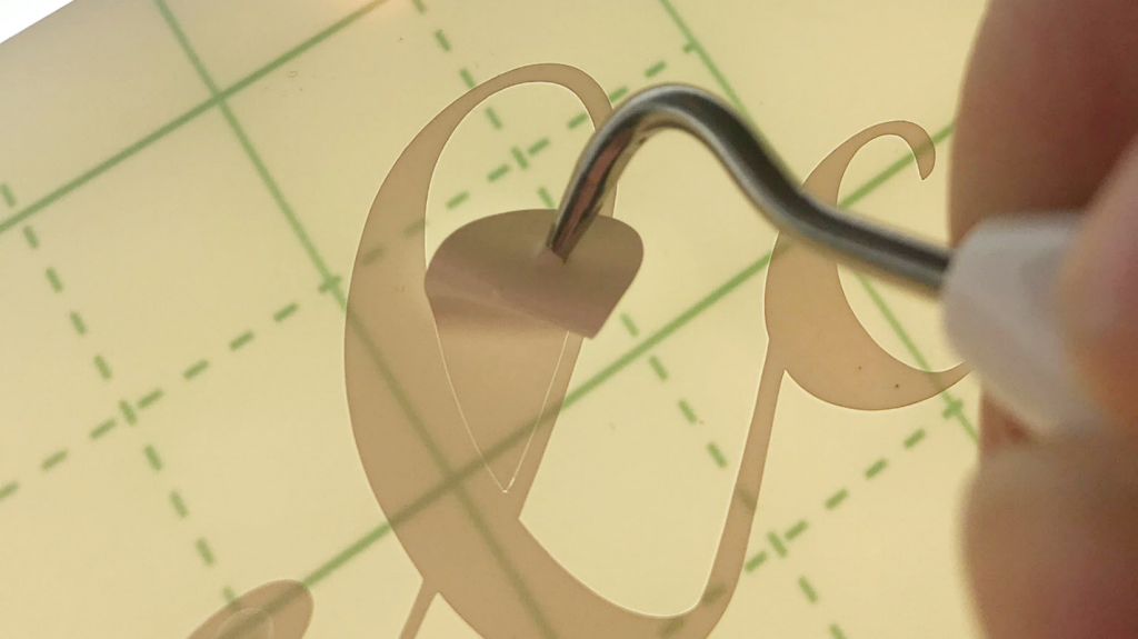 Weeding the letters using the Cricut tool for the sign