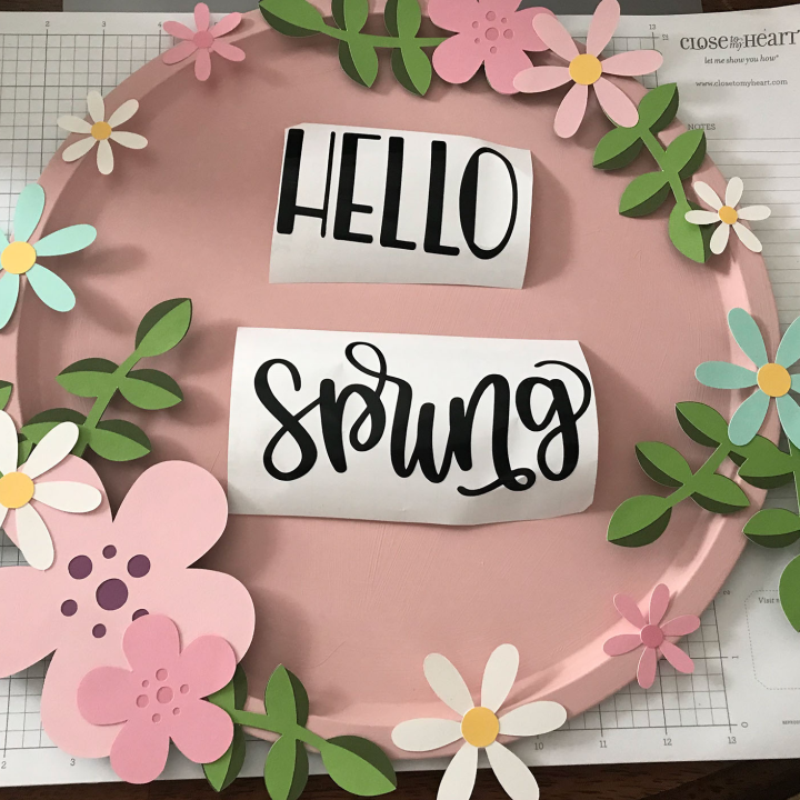 Lay the paper flowers around the edge fo the pizza pan for the spring pizza pan wreath