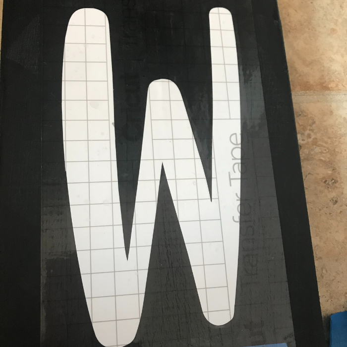 Adding the vinyl letters to the sign with smart vinyl transfer tape