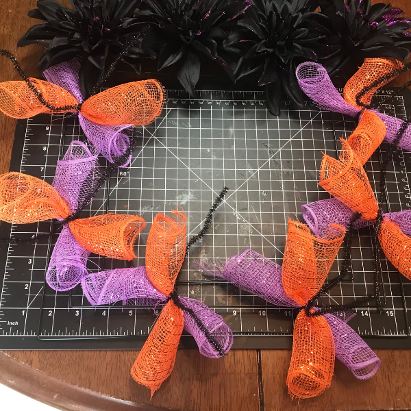 Adding the rolled deco mesh to the square wreath form 
