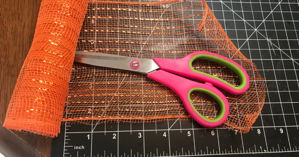 Cutting the dollar tree orange deco mesh for the halloween wreath