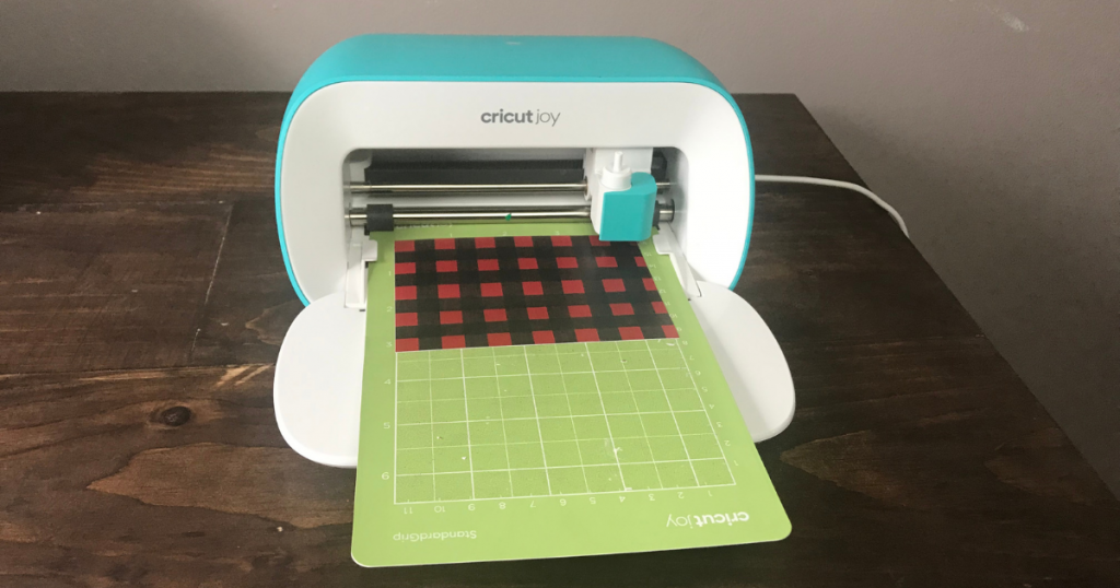 Cricut Joy cutting the buffalo plaid vinyl for the Christmas book stack