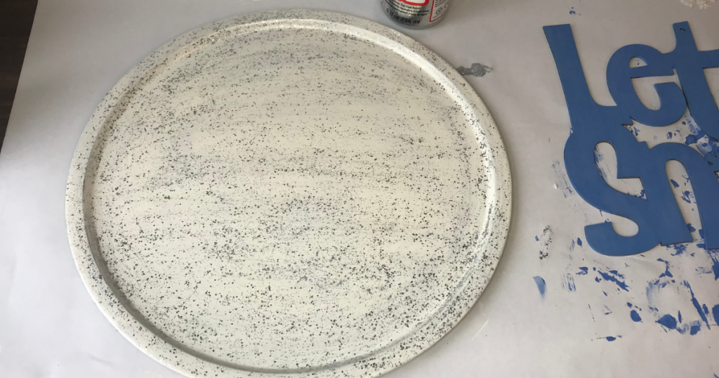 Adding Mod Podge glitter to the pizza pan