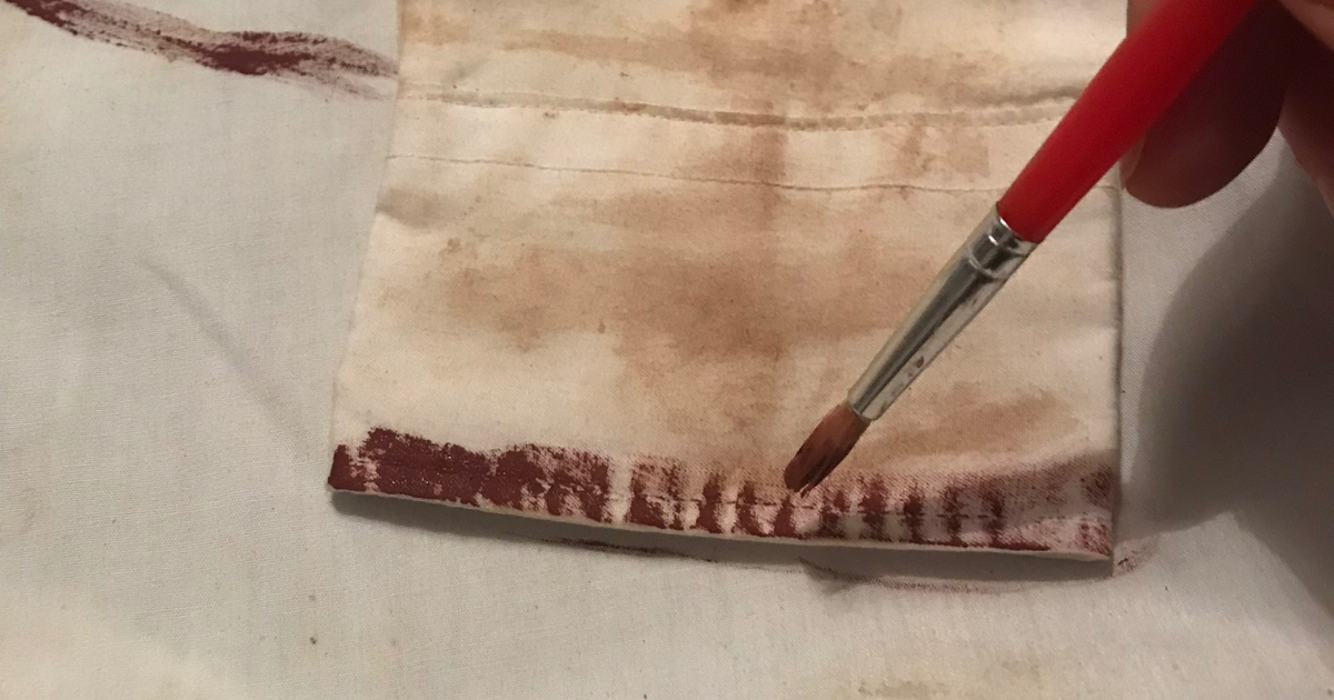 Adding paint to look like dry blood on cuffs of zombie shirt